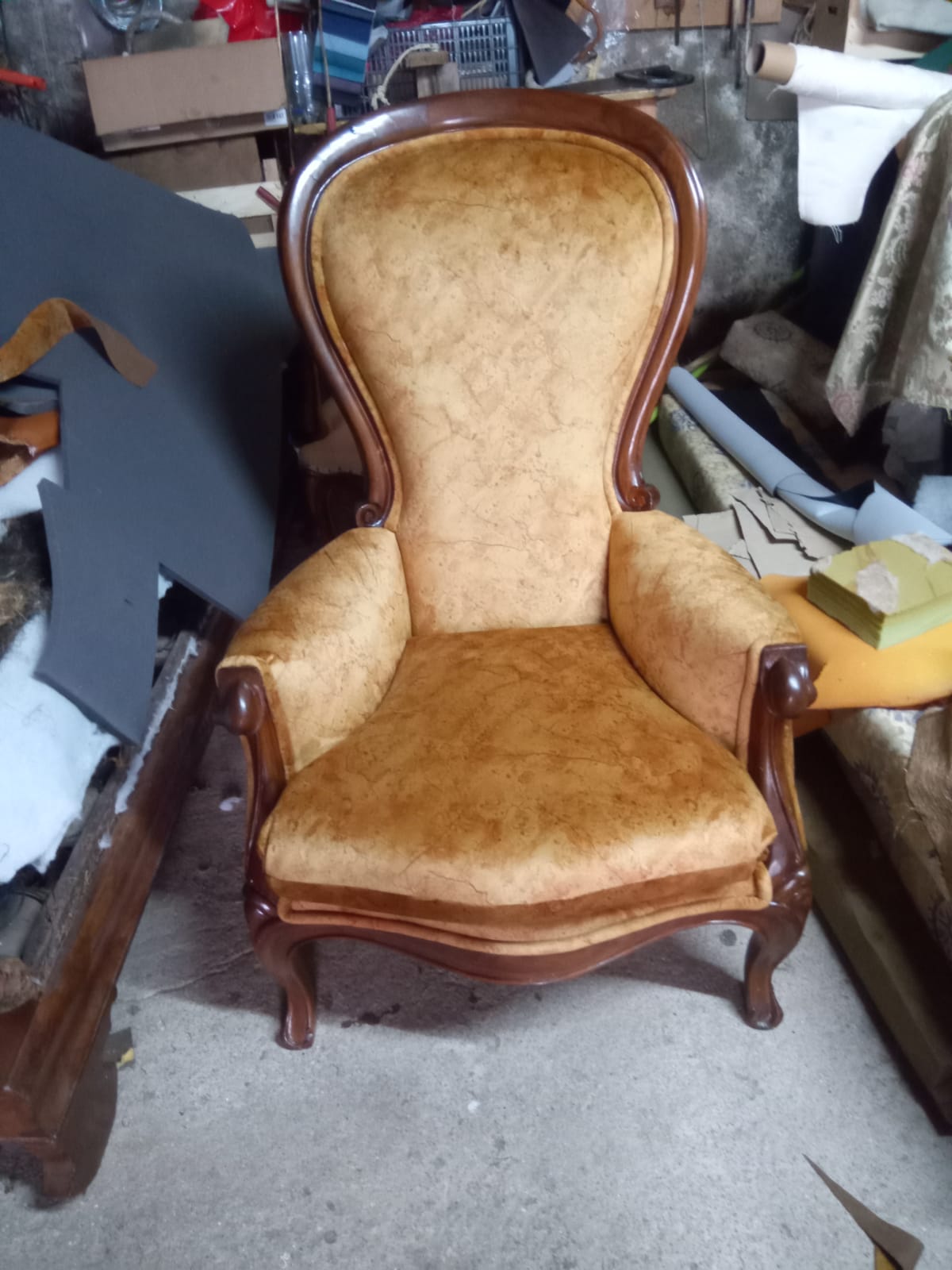 Cadeirão estilo Voltaire com estrutura de madeira escura restaurada e estofo novo em tecido dourado